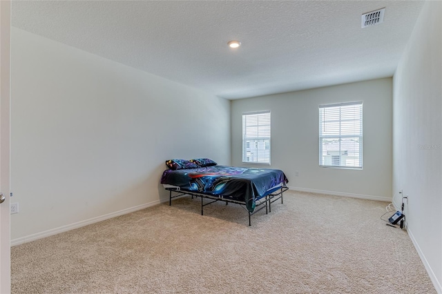 bedroom with a textured ceiling and carpet