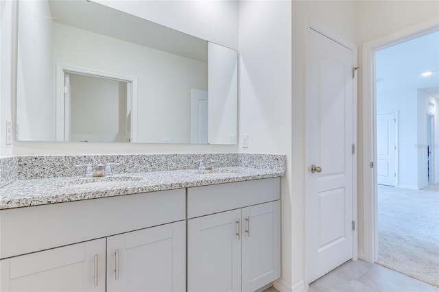 bathroom with tile flooring, dual sinks, and vanity with extensive cabinet space