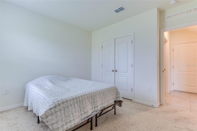 bedroom with a closet and light tile floors