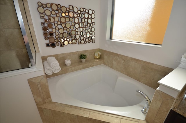 bathroom with a relaxing tiled bath