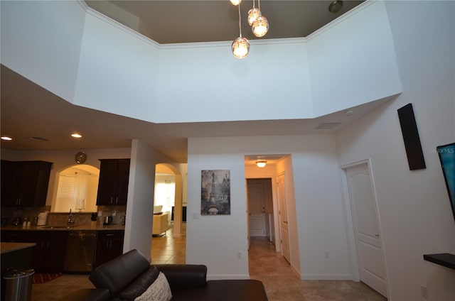 tiled living room with sink and a high ceiling