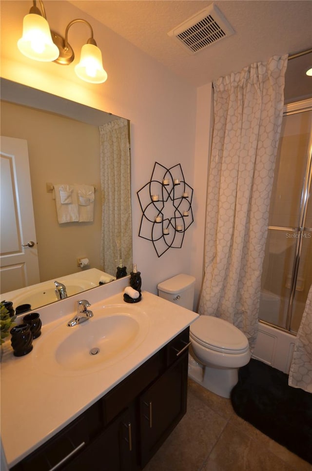 bathroom featuring a shower with door, large vanity, toilet, and tile flooring