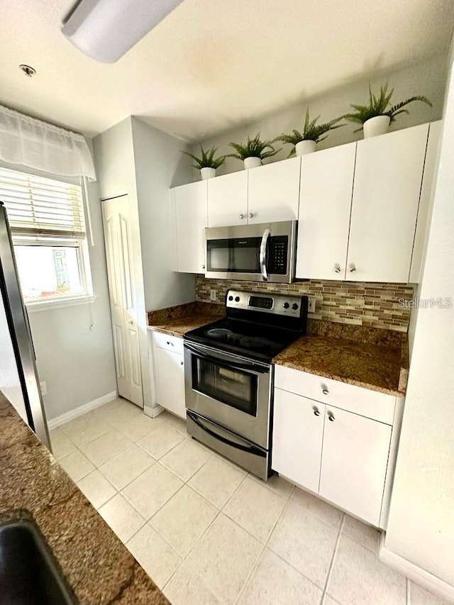 kitchen with white cabinetry, light tile patterned floors, backsplash, and appliances with stainless steel finishes