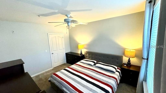 bedroom featuring ceiling fan and dark carpet