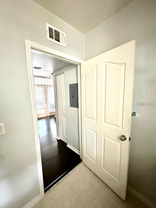 hall with electric panel and light tile patterned flooring