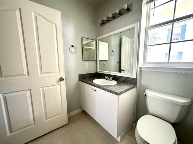 bathroom featuring toilet, vanity, and tile patterned floors