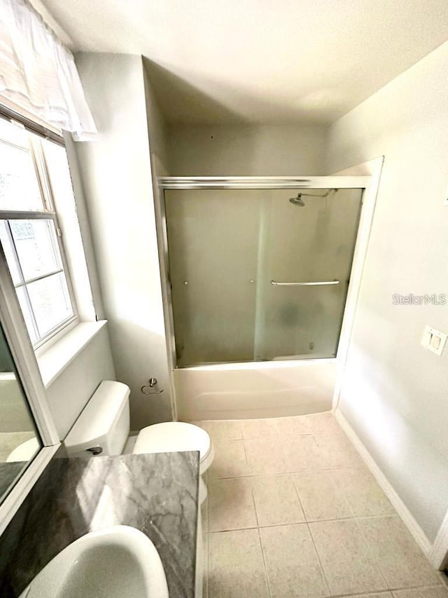 full bathroom with vanity, tile patterned floors, combined bath / shower with glass door, and toilet