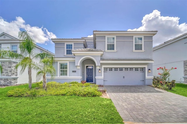 mediterranean / spanish home featuring a garage and a front lawn