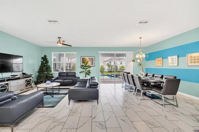 living room with ceiling fan with notable chandelier and light tile floors