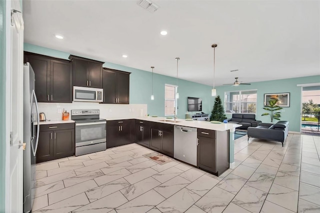 kitchen featuring decorative light fixtures, appliances with stainless steel finishes, kitchen peninsula, and ceiling fan