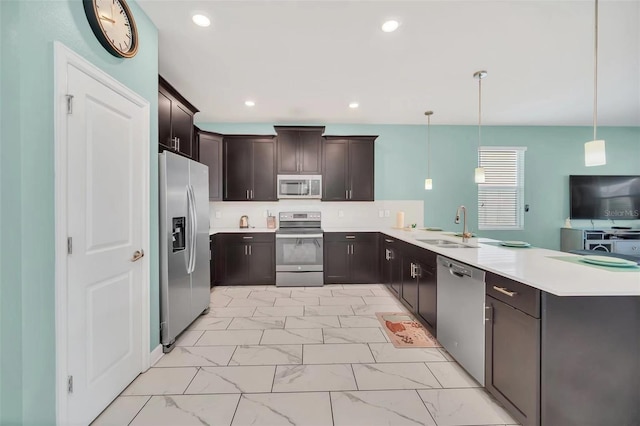 kitchen with kitchen peninsula, stainless steel appliances, sink, and hanging light fixtures