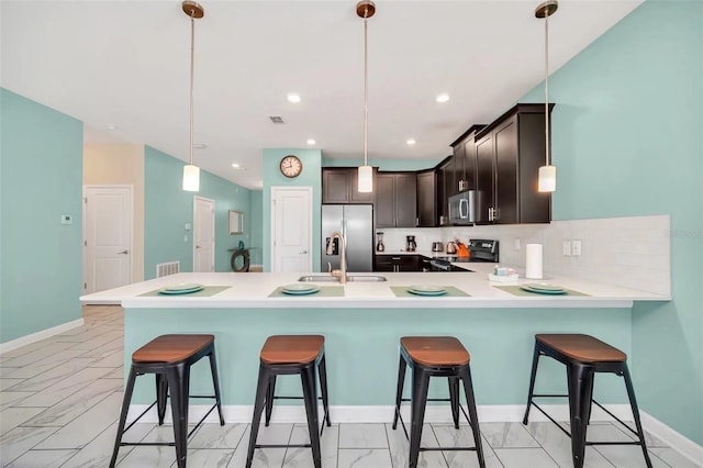 kitchen with pendant lighting, light tile flooring, stainless steel appliances, tasteful backsplash, and dark brown cabinetry