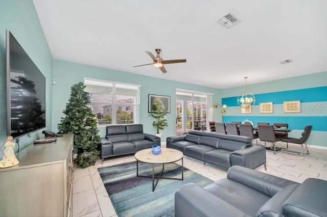 tiled living room featuring ceiling fan with notable chandelier