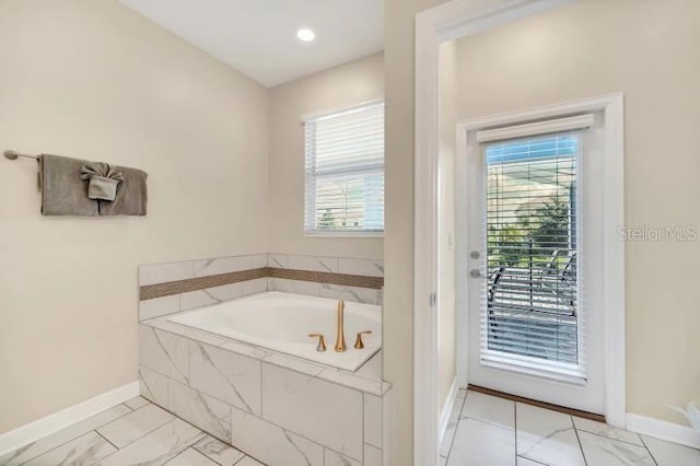 bathroom with a relaxing tiled bath and tile floors