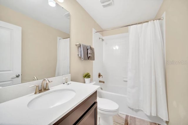 full bathroom featuring shower / bath combo, vanity, and toilet