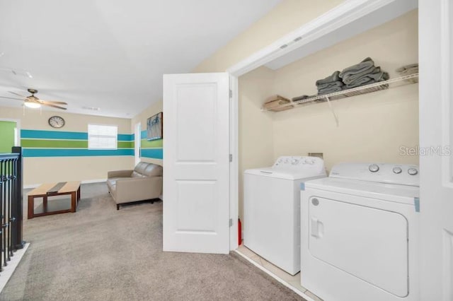 laundry area featuring independent washer and dryer, ceiling fan, and light carpet