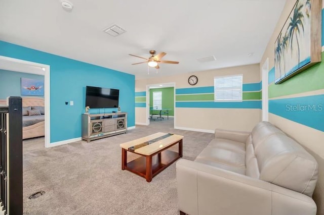 living room featuring a wealth of natural light, ceiling fan, and carpet