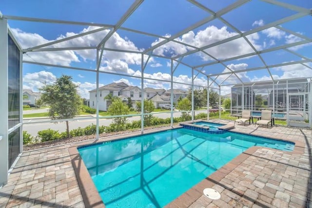 view of swimming pool with a patio, glass enclosure, and an in ground hot tub