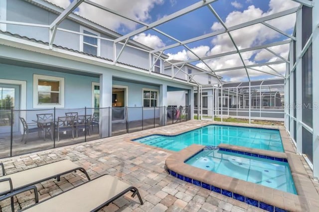 view of pool featuring an in ground hot tub, a lanai, and a patio