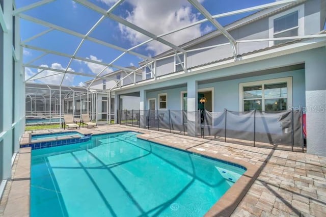 view of swimming pool featuring a patio area, a lanai, and an in ground hot tub