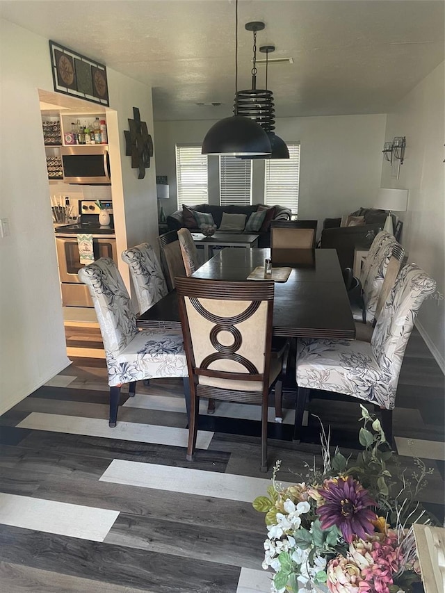 dining space with dark hardwood / wood-style flooring