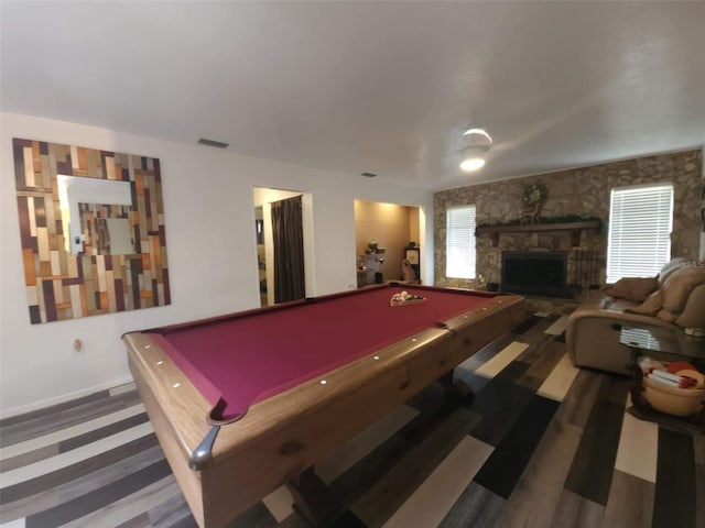 rec room with a stone fireplace, dark wood-type flooring, and pool table