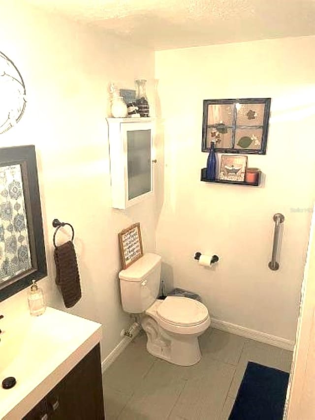 bathroom featuring tile patterned flooring, vanity, and toilet