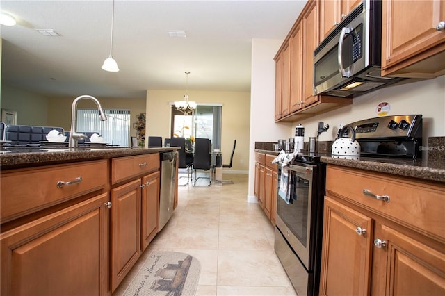 kitchen with decorative light fixtures, light tile flooring, a chandelier, stainless steel appliances, and sink