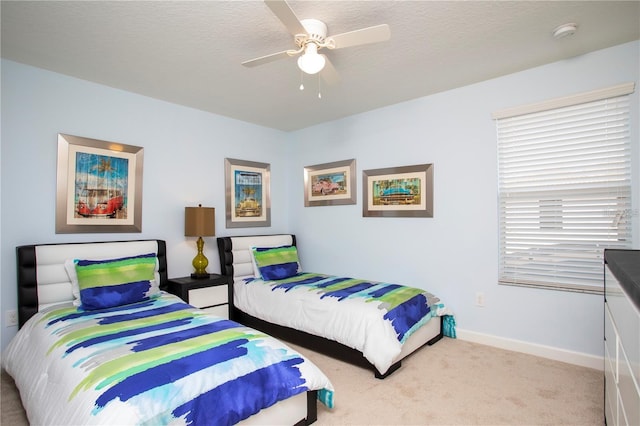 carpeted bedroom featuring ceiling fan and a textured ceiling