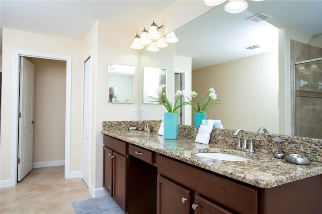 bathroom featuring tile floors, dual bowl vanity, and a textured ceiling