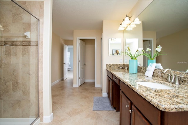 bathroom featuring tile flooring, a textured ceiling, dual sinks, oversized vanity, and a shower with door