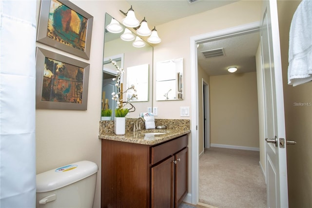 bathroom featuring oversized vanity, toilet, and a textured ceiling