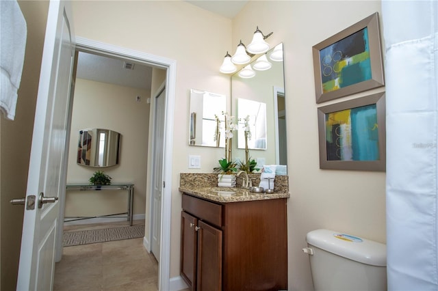 bathroom with tile flooring, oversized vanity, and toilet