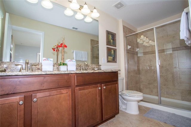 bathroom with a shower with shower door, tile floors, toilet, and dual vanity