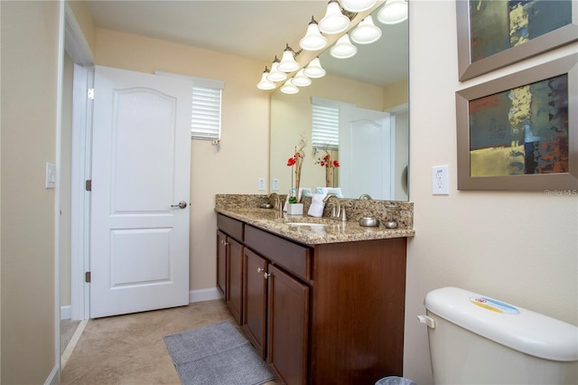 bathroom with toilet, tile floors, and vanity