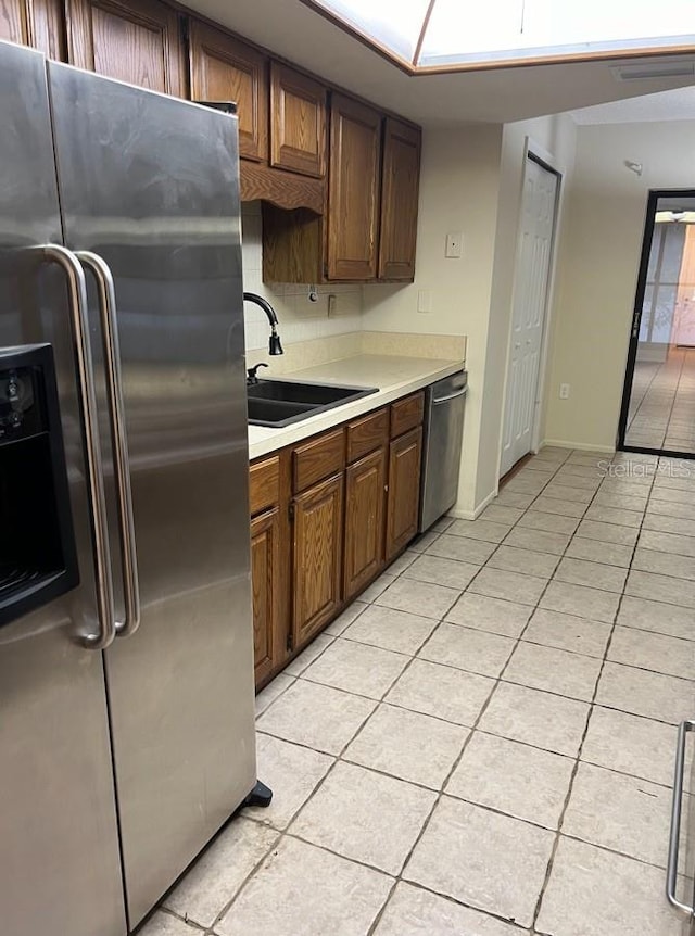 kitchen with sink, light tile floors, and appliances with stainless steel finishes