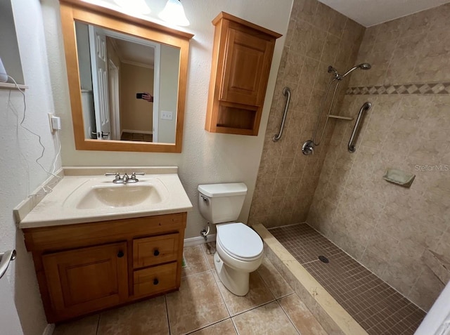 bathroom with a tile shower, tile flooring, vanity, and toilet