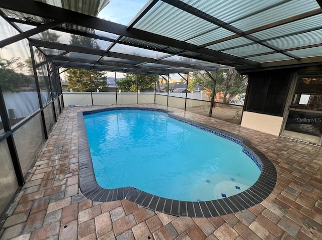 view of pool with a patio area and glass enclosure