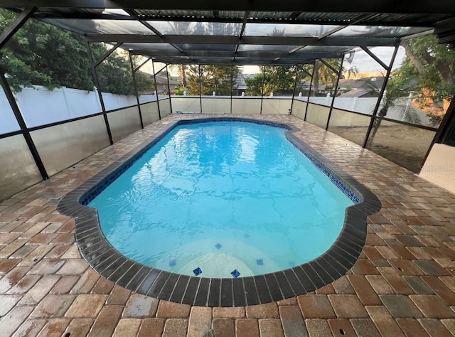 view of swimming pool with a lanai and a patio area