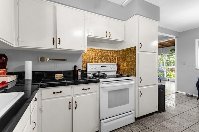 kitchen featuring electric stove, ventilation hood, light tile floors, sink, and white cabinets