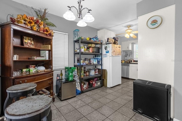 kitchen with white refrigerator, light tile flooring, ceiling fan with notable chandelier, dishwasher, and white cabinets