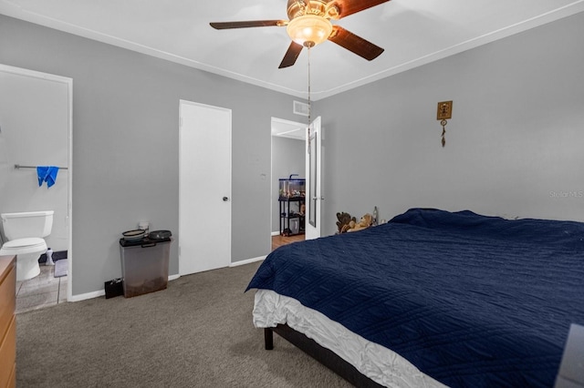 bedroom featuring ornamental molding, ceiling fan, ensuite bath, and dark carpet