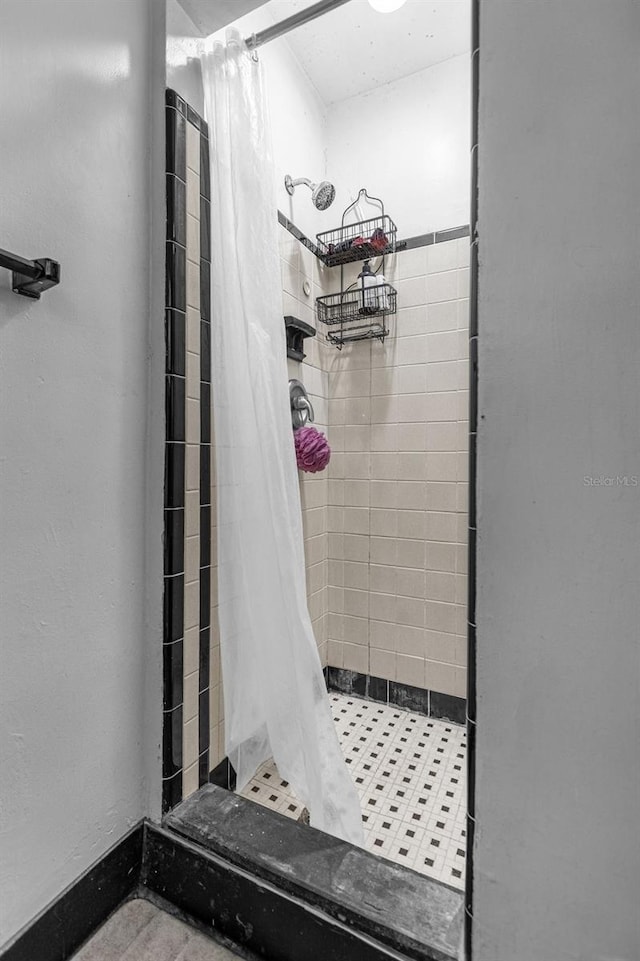 bathroom with curtained shower and tile flooring