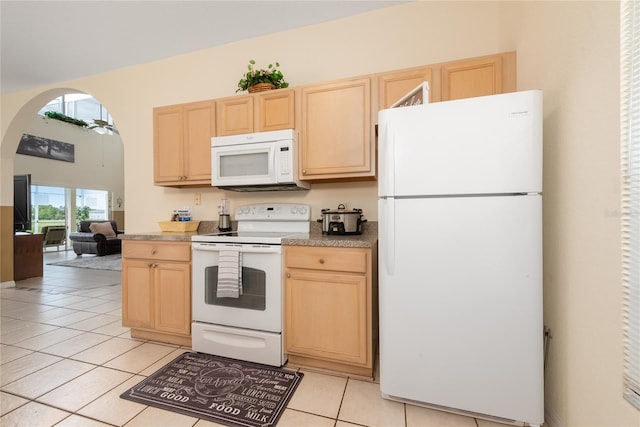 kitchen with light brown cabinets, white appliances, and light tile floors