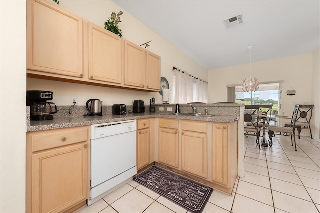 kitchen with kitchen peninsula, white dishwasher, light tile floors, sink, and a chandelier