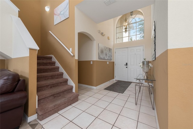 entryway with a high ceiling and light tile flooring