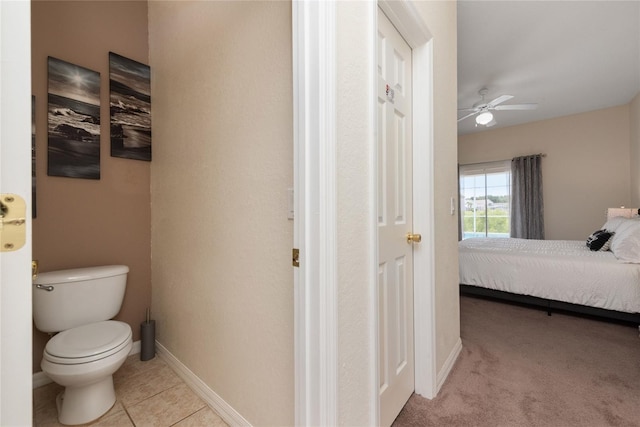 bathroom with tile flooring, ceiling fan, and toilet