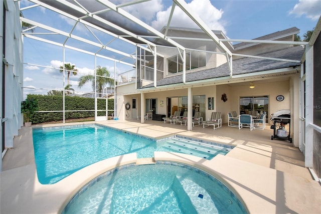 view of swimming pool featuring a lanai, an in ground hot tub, and a patio area