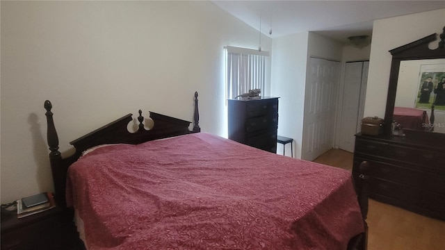 bedroom featuring a closet, hardwood / wood-style flooring, and lofted ceiling