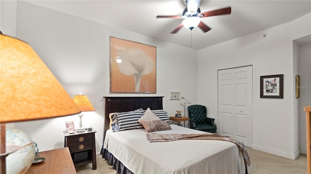 carpeted bedroom featuring ceiling fan and a closet